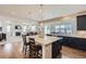 Open kitchen featuring a large island with granite countertops, dark wood cabinets and an adjacent living room at 12578 Hudson Ct, Thornton, CO 80241