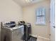 Well-lit laundry room equipped with modern, front-loading washer and dryer and a window providing natural light at 12578 Hudson Ct, Thornton, CO 80241