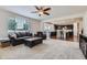Open living room featuring a fireplace, neutral carpet, and an open view of the modern kitchen and dining area at 12578 Hudson Ct, Thornton, CO 80241