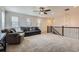 Spacious loft featuring plush carpeting, neutral walls, ceiling fan, and a stairway with decorative metal banister at 12578 Hudson Ct, Thornton, CO 80241