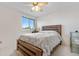 Well-lit bedroom featuring a ceiling fan, large window and a wooden bed frame at 20835 E 47Th Ave, Denver, CO 80249