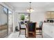 Bright dining area with a glass table, black chairs, tile floors, and sliding glass door leading to the backyard at 20835 E 47Th Ave, Denver, CO 80249