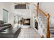 Bright living room featuring high ceilings, tile flooring, cozy fireplace, and staircase to upper level at 20835 E 47Th Ave, Denver, CO 80249