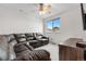 Living room with a comfortable, oversized leather sectional sofa and large window at 20835 E 47Th Ave, Denver, CO 80249