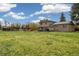 Expansive backyard with lush green grass, playground, storage sheds, and patio area with seating at 1866 Mountain View St, Erie, CO 80516