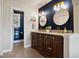 Bathroom featuring a dark blue accent wall with gold fixtures, a double vanity, and a separate water closet at 1866 Mountain View St, Erie, CO 80516