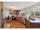 Well-lit kitchen features wood cabinets, stainless steel appliances, and a hardwood floor at 1866 Mountain View St, Erie, CO 80516