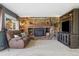 Cozy living room featuring stone fireplace, a leather sofa, and built-in shelving at 1866 Mountain View St, Erie, CO 80516