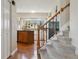 Inviting staircase with wooden handrail and carpeted steps, leading to a bright, sunlit kitchen at 1866 Mountain View St, Erie, CO 80516