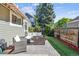 Outdoor patio with seating and a view of the fenced backyard with artificial turf at 4720 S Dudley St # 38, Littleton, CO 80123