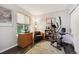 Bright exercise room with hardwood floors, a comfortable arm chair, and a stationary bike next to the window at 4720 S Dudley St # 38, Littleton, CO 80123