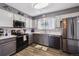 Modern kitchen featuring gray and white cabinets, stainless steel appliances, a mosaic backsplash, and hardwood floors at 4720 S Dudley St # 38, Littleton, CO 80123
