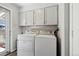Functional laundry room with washer, dryer, and overhead storage cabinets at 4720 S Dudley St # 38, Littleton, CO 80123