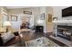 Spacious living room with a stone fireplace, hardwood floors, and a comfortable leather sofa and arm chair at 4720 S Dudley St # 38, Littleton, CO 80123