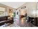 Cozy living room flowing to a study room with hardwood floors, with a comfortable leather sofa and arm chair at 4720 S Dudley St # 38, Littleton, CO 80123