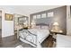 Bedroom featuring a large bed with an decorative iron headboard, mirrored closet, and neutral decor at 4720 S Dudley St # 38, Littleton, CO 80123
