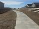 Winding concrete walking path with wood fence, xeriscaping, and community homes nearby at 9444 Yampa St, Commerce City, CO 80022