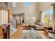 Open-concept living room with hardwood floors, a neutral sofa, and large windows for natural light at 420 Graham Cir, Erie, CO 80516