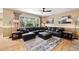 Comfortable living room featuring a large leather sectional, a ceiling fan, and backyard views at 420 Graham Cir, Erie, CO 80516
