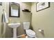 A charming powder room featuring a pedestal sink and a decorative mirror on the wall at 420 Graham Cir, Erie, CO 80516