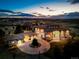 Stunning aerial view of estate home with circular driveway and city view beyond at dusk at 10177 Rancho Montecito Dr, Parker, CO 80138