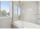 Bright bathroom with a soaking tub enclosed by glass and a window view at 10177 Rancho Montecito Dr, Parker, CO 80138