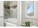 Bright bathroom featuring a tub with jets, frameless glass door, and large window at 10177 Rancho Montecito Dr, Parker, CO 80138