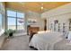 Sunlit bedroom featuring a wood ceiling, large windows with scenic views, and built-in shelving at 10177 Rancho Montecito Dr, Parker, CO 80138