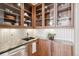 Butler's pantry features glass front cabinets, granite countertop, and stainless steel sink at 10177 Rancho Montecito Dr, Parker, CO 80138