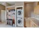 Well-organized laundry area with stacked washer/dryer and custom shelving and sink at 10177 Rancho Montecito Dr, Parker, CO 80138