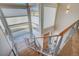 Modern staircase with wood steps, glass railings, and natural light from large windows at 10177 Rancho Montecito Dr, Parker, CO 80138