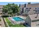 Community outdoor pool with lounge chairs and umbrellas with a view of the community townhomes at 5250 S Huron Way # 5-308, Littleton, CO 80120