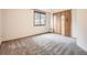 This bedroom features neutral carpeting, a window, and a closet with light wood doors at 9670 W 69Th Ave, Arvada, CO 80004