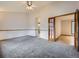 Carpeted bedroom featuring a large doorway and a door to an ensuite bathroom at 9670 W 69Th Ave, Arvada, CO 80004
