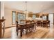 Open dining room with hardwood floors, chandelier, and views to the kitchen and outside at 9670 W 69Th Ave, Arvada, CO 80004