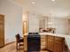 Well-lit kitchen featuring hardwood floors and wood cabinetry, with a view to the dining room at 9670 W 69Th Ave, Arvada, CO 80004
