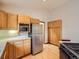 Kitchen featuring stainless steel refrigerator, wood cabinets and hardwood floors at 9670 W 69Th Ave, Arvada, CO 80004