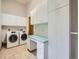 This laundry room features a washer and dryer, cabinets, and storage at 9670 W 69Th Ave, Arvada, CO 80004