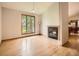 Bright living room with hardwood floors, fireplace, and large window letting in natural light at 9670 W 69Th Ave, Arvada, CO 80004
