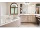 Bright bathroom featuring a soaking tub with window and a dual sink vanity at 9670 W 69Th Ave, Arvada, CO 80004