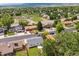 Wide aerial shot showing the neighborhood, homes, tree coverage, and roads on a sunny day at 13051 W Jewell Cir, Lakewood, CO 80228