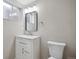 Bathroom features a modern vanity, a framed mirror, and a nearby toilet, complemented by a window for natural light at 13051 W Jewell Cir, Lakewood, CO 80228