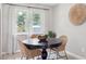 Cozy dining area featuring wood table, modern decor, large window, and natural lighting at 13051 W Jewell Cir, Lakewood, CO 80228