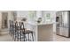 Bright kitchen featuring quartz counters, stainless appliances, island with seating, and stylish decor at 13051 W Jewell Cir, Lakewood, CO 80228