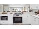 Bright kitchen featuring quartz counters, stainless appliances, and stylish white cabinetry at 13051 W Jewell Cir, Lakewood, CO 80228