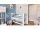 Bedroom with a crib, neutral color scheme, and access to laundry at 3720 S Hazel Ct, Englewood, CO 80110