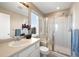 This bathroom has a tiled glass shower, large mirror, and bright window at 658 Casper Dr, Lafayette, CO 80026