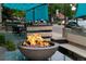 Cozy patio with a stone fire pit, bench seating and overhead string lights at 658 Casper Dr, Lafayette, CO 80026