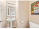 Compact powder room featuring pedestal sink, toilet, and simple decor at 658 Casper Dr, Lafayette, CO 80026