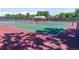 View of green and red tennis courts in a fenced-in area with shadow coverage at 658 Casper Dr, Lafayette, CO 80026